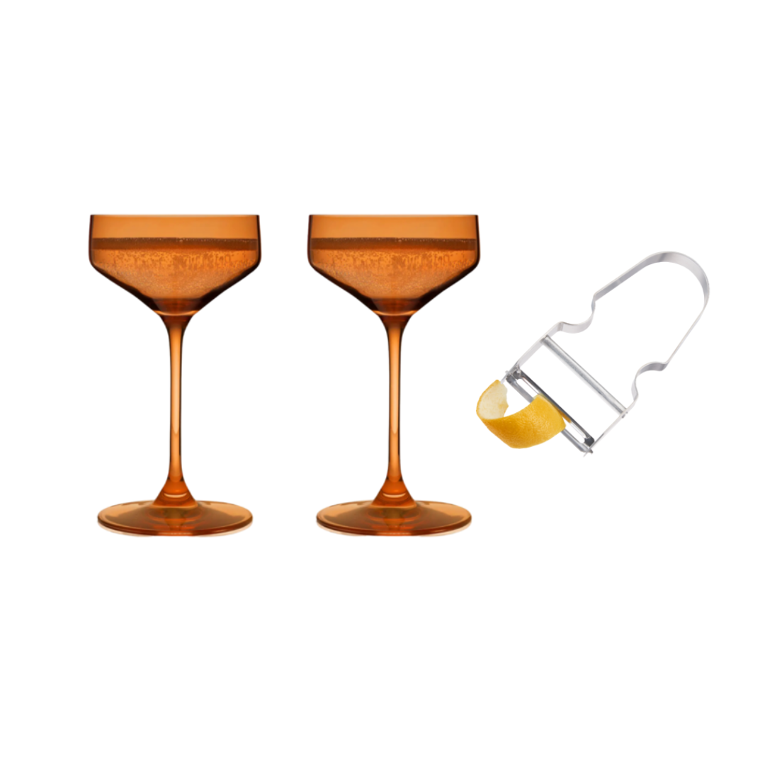 Two orange Reserve Nouveau Crystal Coupes and a orange glasses with a drink and multicolored glasses